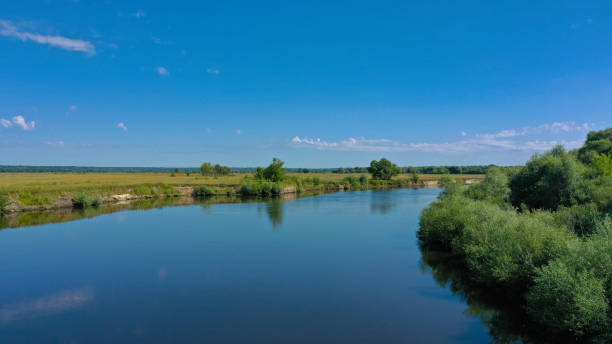 vue aérienne d’un beau paysage d’été au-dessus de fleuve tandis que l’aube. vue supérieure au-dessus de la rivière avec une surface lisse d’eau reflétant le ciel bleu. - horizon over water horizontal surface level viewpoint photos et images de collection