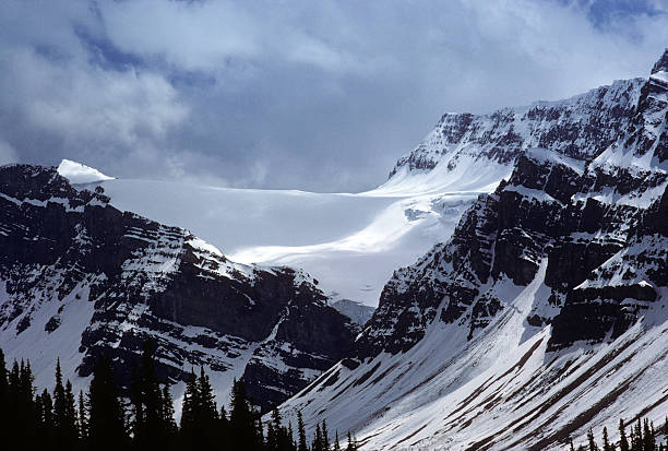Glacier near Banff, 1975 A glacier and mountainside near Banff, in Canada, with treeline barely visible in the foreground. hearkencreative stock pictures, royalty-free photos & images