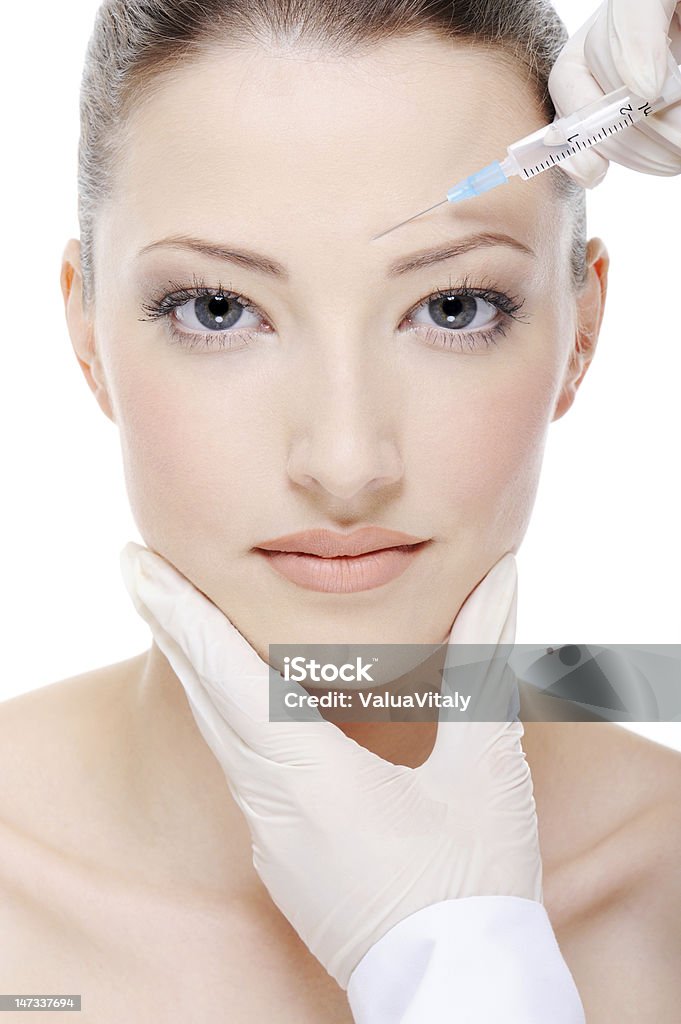 Beautiful young woman receiving a facial injection beautician giving an injection on the young female face 20-29 Years Stock Photo