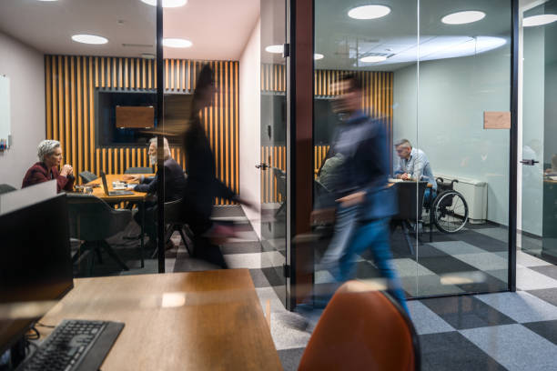 istock Blurred Businessman Moving Through Busy Office 1473377707