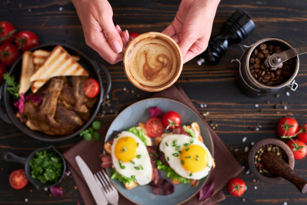 istock Tasty breakfast - fried egg toasts, bacon, tomatoes on wooden kitchen table 1473377767