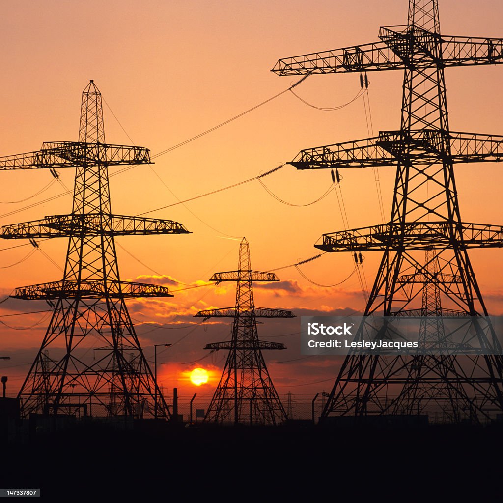 Pylônes électriques dans le coucher de soleil - Photo de Centrale nucléaire libre de droits