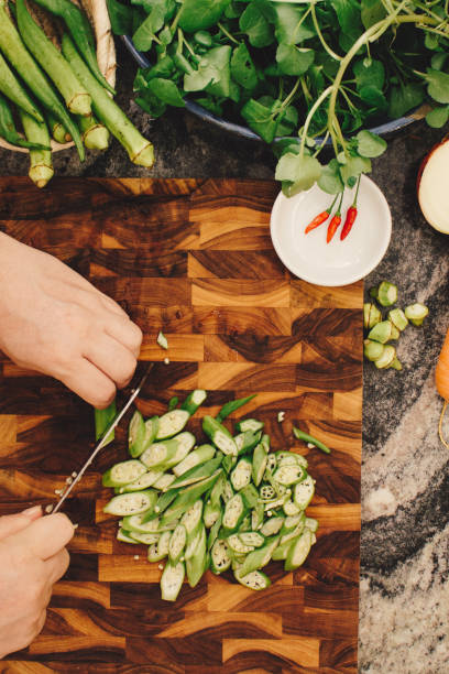 istock Vegan Cooking: Chopping Okra on a Wooden Board 1473380524