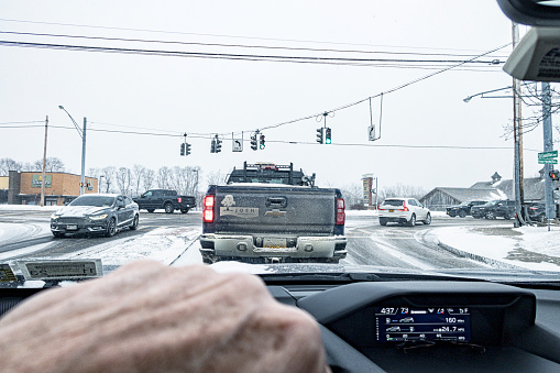Winter vehicle traffic turning and waiting for signal lights to change at a shopping center road Intersection along Fairport–Nine Mile Point Road (NY State Route 250) in Penfield, New York on February 3, 2023.