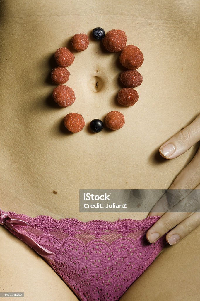 Fruit Cycle Strawberries and Blueberries rest on a female stomach depicting life cycle Life Cycle Stock Photo