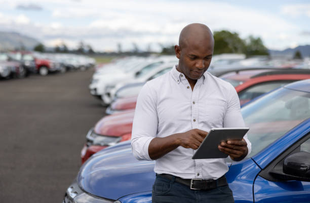 태블릿을 사용하여 자동차 대리점에서 일하는 자동차 판매원 - car old african descent car salesperson 뉴스 사진 이미지