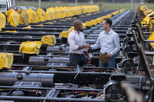 Latin American client buying a truck chassis at the car dealership and closing a deal with a handshake