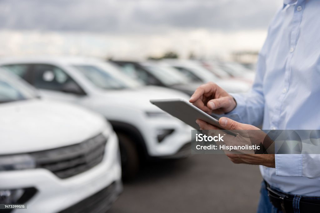 Close-up on a car salesperson using a tablet computer - Royalty-free Autodealer Stockfoto Close-up on a car salesperson using a tablet computer - Royalty-free Autodealer Stockfoto