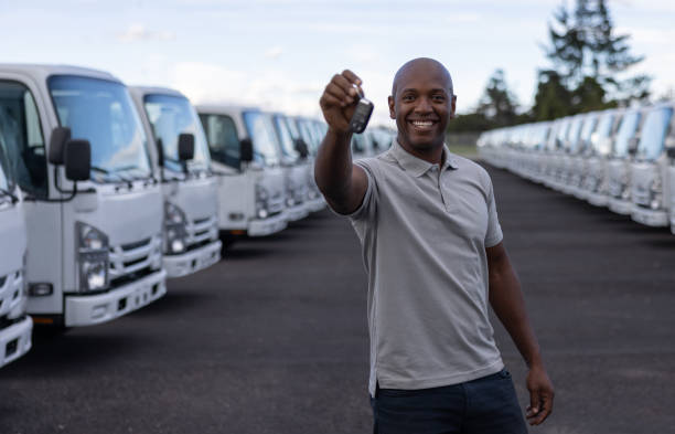 uomo felice alla concessionaria con le chiavi del suo nuovo camion - truck key foto e immagini stock