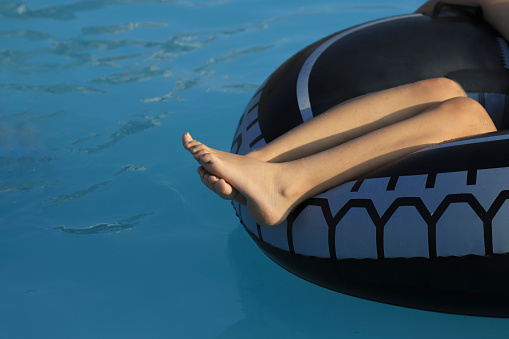 Teenager's feet on float in the pool