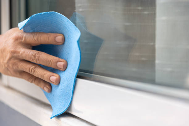 Worker use a soft cloth cleaning uPVC aluminum window frames  remove a small dirty after install. stock photo
