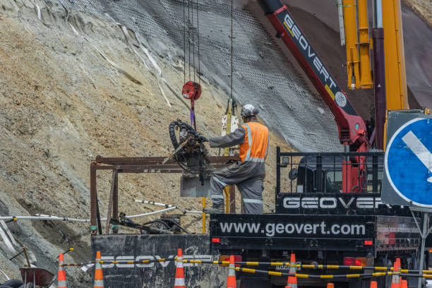 Worker with machinery at roadworks stock photo