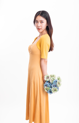 A woman in a yellow dress holding a pot of flowers