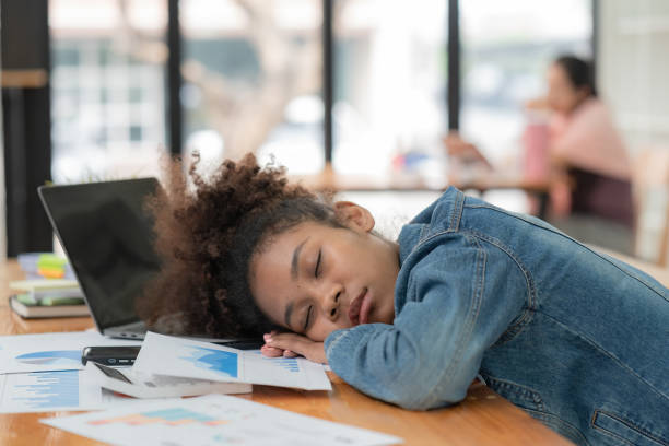 istock Sleep, burnout or businesswoman sleeping in the office, sick or stressed with work depression or mental health fatigue. Tired, anxious, or a black woman frustrated, lazy, or sleepy at a desk in the office. 1473404309