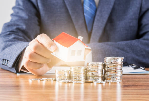 istock A model of a house held by a businessman 1473411389