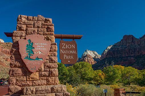 Entrance sign to Zion National Park during the peak fall season.