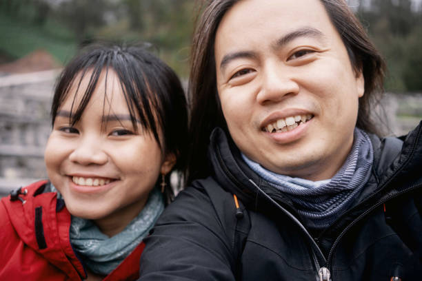 istock Happy Asian Couple Taking Selfie Wearing Red Black Jacket 1473414892