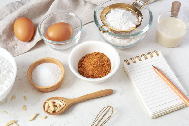 istock Baking pastry or cake ingredients, flour, brown sugar, milk on marble table with notebook and pen 1473415926
