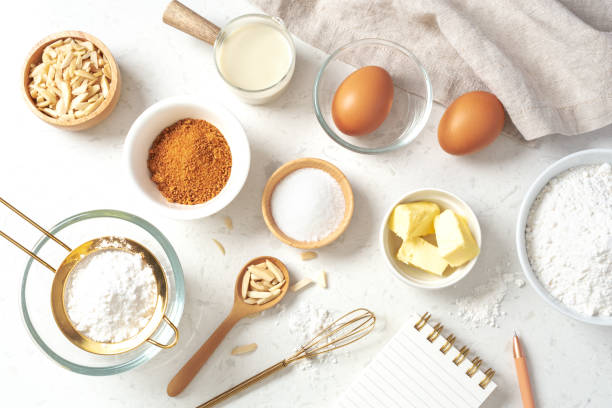 istock Baking pastry or cake ingredients, sugar, flour, eggs and milk with notebook and pen on marble table 1473415997