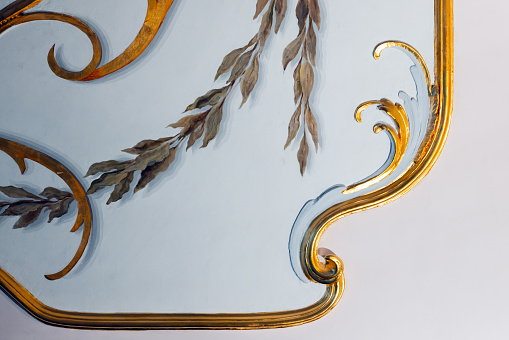 Classic vintage luxury interior details, gold colored elements of gypsum wall decoration and floral fresco fragment