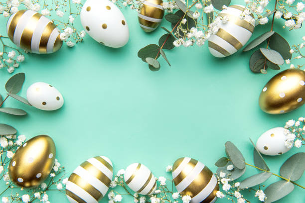 istock Easter eggs painted in gold and eucalyptus branches on a soft green background. 1473419100