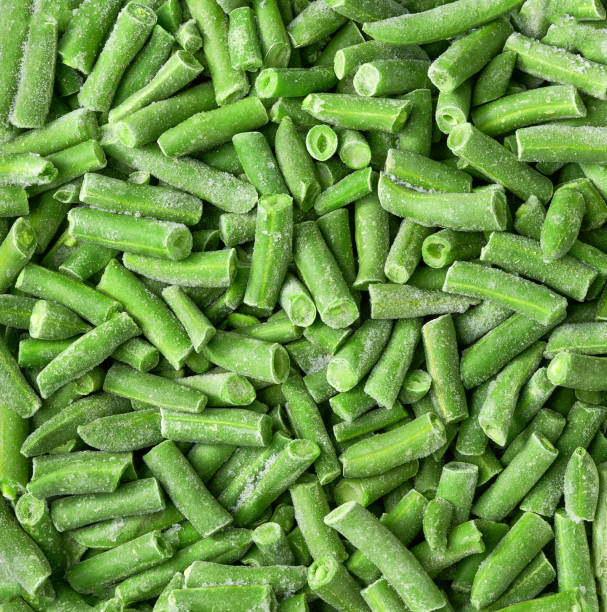 istock Frozen cut green beans close up top view background. 1473420044