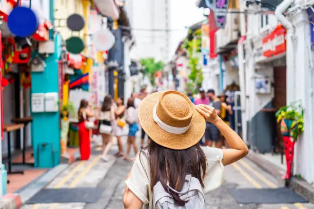 Young woman tourist with backpack walking at Haji Lane in Singapore