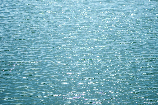Shining blue sea water surface texture background.