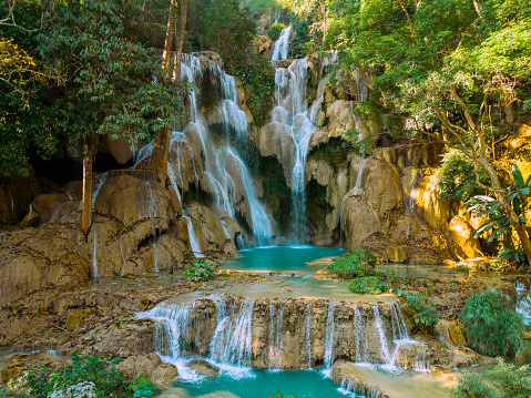 Young woman contemplating a beautiful waterfall on the Cebu Island in the Philippines. People travel nature loving concept. One person only enjoying outdoors and tranquillity in a peaceful environment