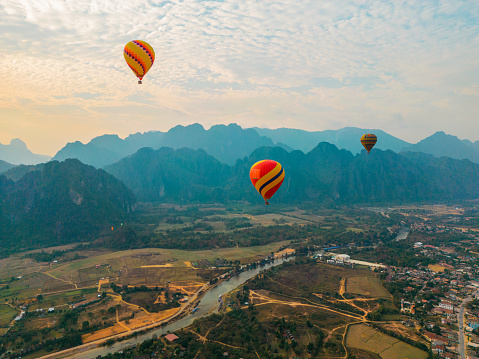 Scenic aerial view of red hot air balloon above the valley