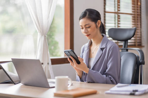 istock Happy Young Asian woman using laptop while working at home with documents. online documentation calculator to calculate the numbers, finance accounting office concept 1473429490
