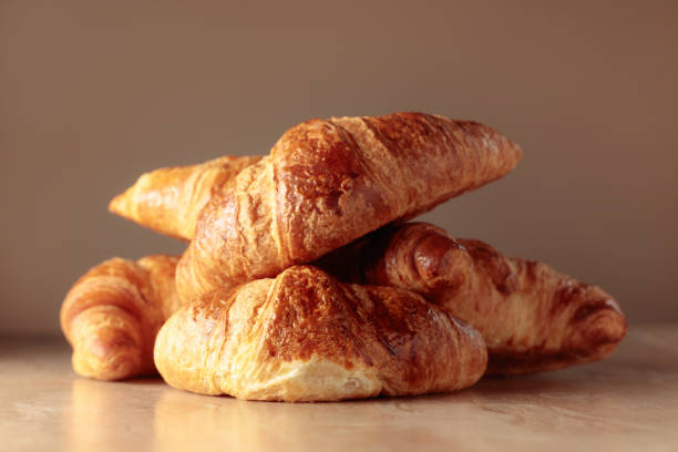 istock Freshly baked croissants on a beige ceramic table. 1473430626