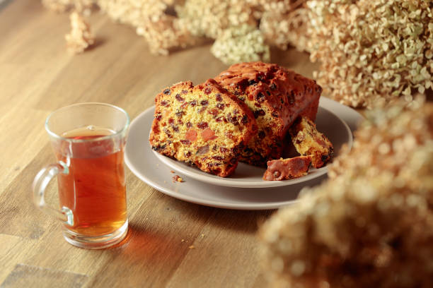 istock Fruit cake and tea on a wooden table with dried flowers. 1473430684