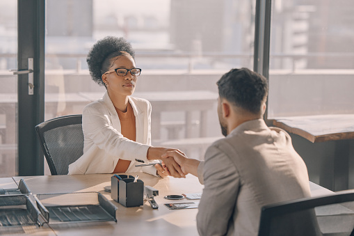 Black woman, shaking hands or meeting in office job interview, human resources or hr collaboration. Serious, success or businessman handshake with manager, CEO or leadership in teamwork partnership