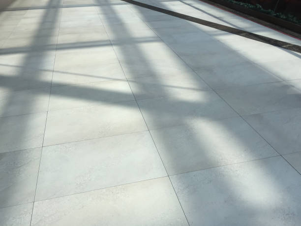 istock Ceramics tiled floor with sunlight and shadow. Modern granite tile floor 1473432999