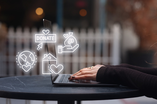 Woman using laptop with donate icons