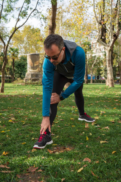 istock Mature man stretching in the park before jogging 1473433755