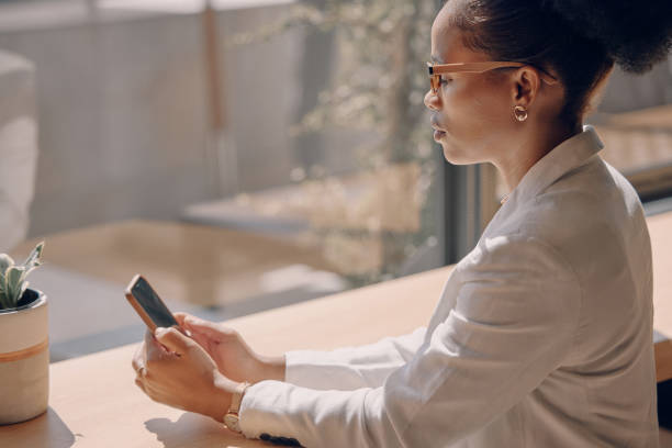istock Workspace, phone and professional black woman typing, networking and reading email on mobile app or chat. African business person or online entrepreneur, smartphone or cellphone, internet and web 3.0 1473433812
