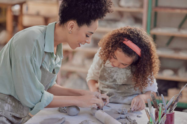 istock Art, sculpting and mother with child in sculpture class, teaching and learning, bonding and ceramic workshop. Black woman, girl and artistic hobby, clay and creativity, pottery in creative studio 1473436097