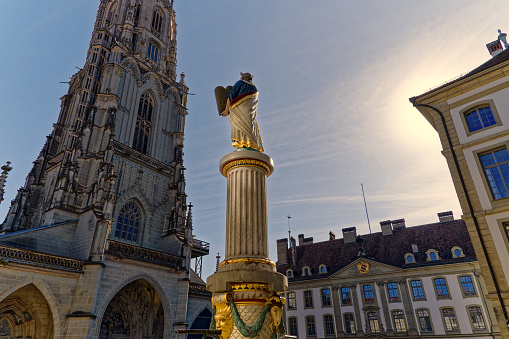 Statue of Moses with stone table and ten commandments at Minster Square with Berner Münster church at the old town of City of Bern on a sunny winter day. Photo taken February 21st, 2023, Bern, Switzerland.