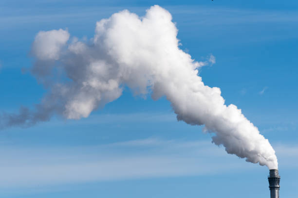 istock Chimney with huge emission cloud in front of blue sky 1473437375