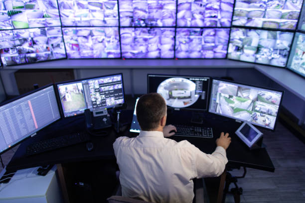 istock Man working in surveillance room and looking at monitors 1473443388