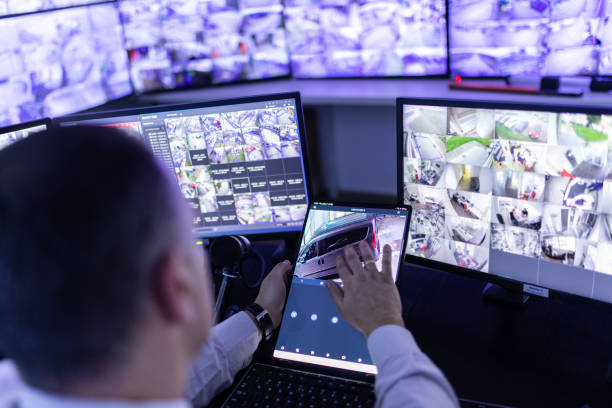 Man working in surveillance room and looking at monitors