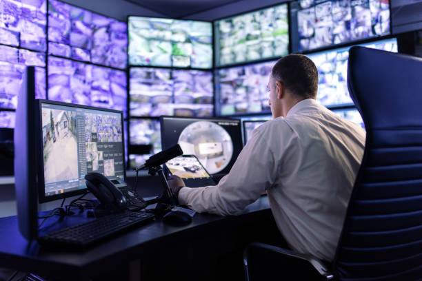 istock Man working in surveillance room and looking at monitors 1473443408