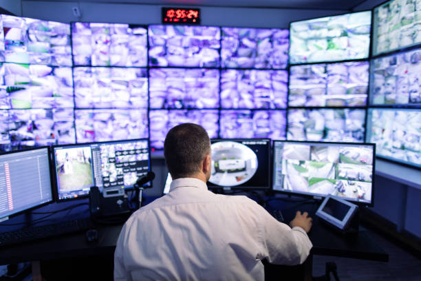 istock Man working in surveillance room and looking at monitors 1473443419