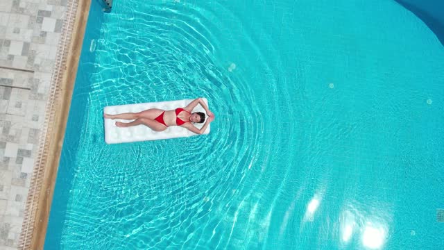 Young woman having fun on sea ring in the pool.