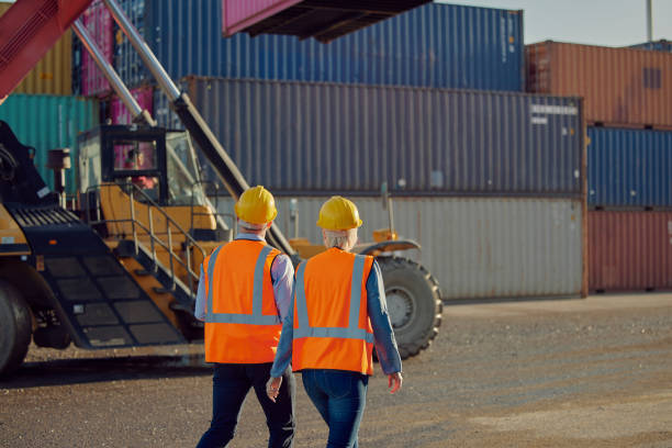 istock Logistics, walking or people at a container supply chain, delivery or shipping distribution warehouse. Back view or industry employees with cargo, stock or inventory at trade port in Dallas, Texas 1473445546