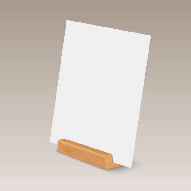 istock Vector 3d Realistic White A4, A5 Vertical Empty Blank Paper Sheet, Card on Wooden Holder, Stand Icon Closeup. Design Template for Mockup, Menu Frame, Booklets. Acrylic Tent Card. Half Turn, Side View 1473446608