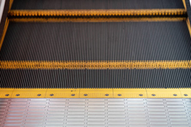 istock moving steps at the bottom of a conventional escalator. 1473447036