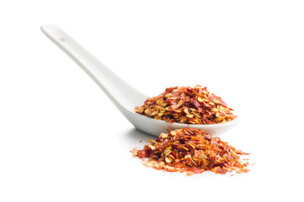 istock Dry chili pepper flakes in ceramic spoon. Crushed red peppers 1473449566